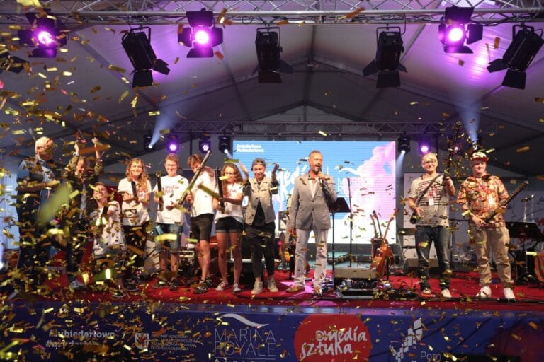 Koncert na scenie z konfetti i publicznością.