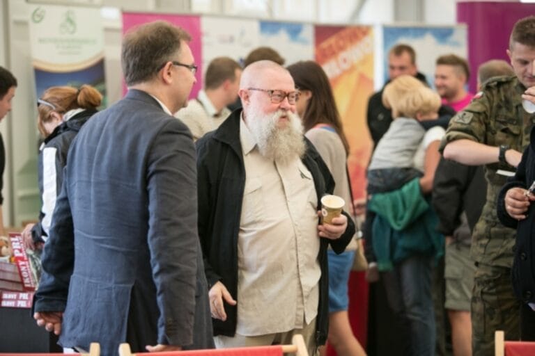 Rozmowa dwóch starszych mężczyzn na targach.