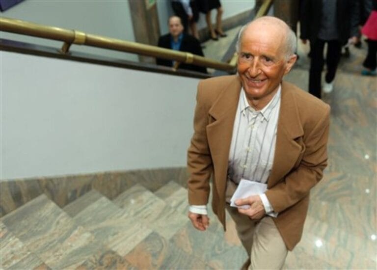 Starszy mężczyzna w garniturze idzie po schodach.