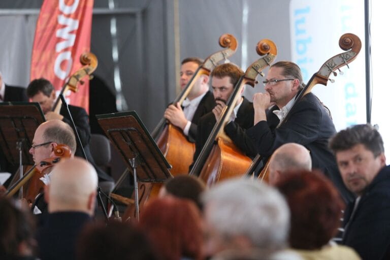 Muzycy orkiestry grają na kontrabasach podczas koncertu
