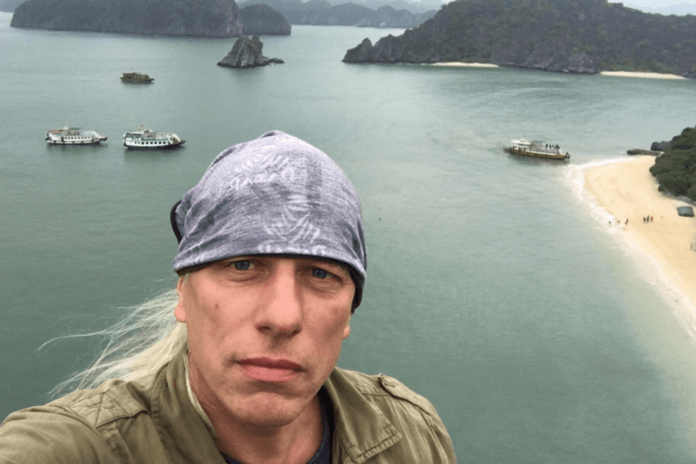 Mężczyzna nad zatoką i łodzią na plaży.