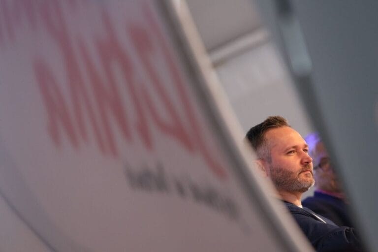 Mężczyzna siedzący na konferencji, zaciekawiony