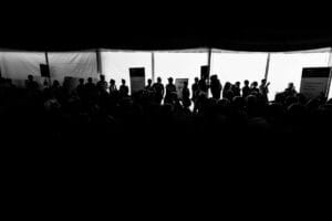 Tłum ludzi w ciemnym namiocie na wydarzeniu.