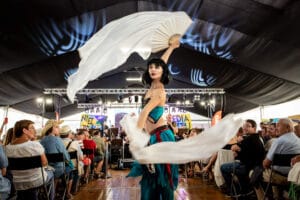 Tancerka z wachlarzem na festiwalu, scena pełna widzów.