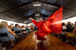 Tancerz w czerwonej sukni na scenie.