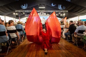 Tancerz w czerwonym stroju z wachlarzem na scenie