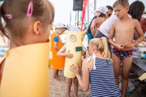 Dzieci bawią się w przebraniu robotów na plaży.