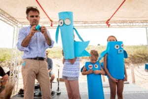 Dzieci w kostiumach morskich, budują rekwizyty na plaży.