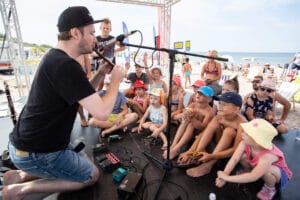 Muzyk gra dla dzieci na plaży.