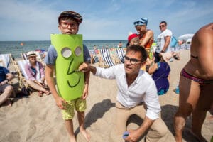 Mężczyzna i dziecko na plaży w zabawnym stroju.