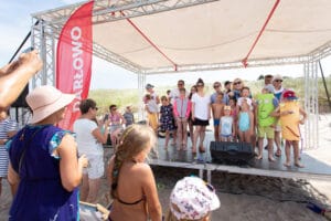 Ludzie na scenie nad morzem z dziećmi.