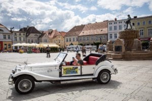 Zabytkowy samochód na rynku w polskim mieście.