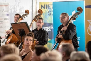 Muzycy z kontrabasami na koncercie orkiestry.