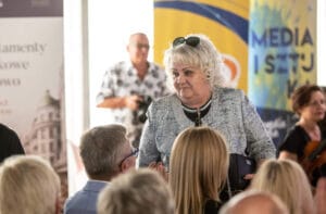 Kobieta rozmawia z publicznością na wydarzeniu.