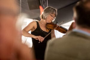 Kobieta gra na skrzypcach podczas występu.