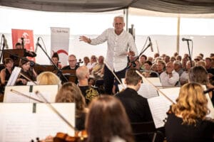 Dyrygent prowadzi orkiestrę na koncercie muzyki klasycznej.