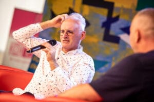 Mężczyzna z mikrofonem na kolorowej scenie