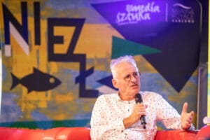 Mężczyzna z mikrofonem na scenie artystycznej