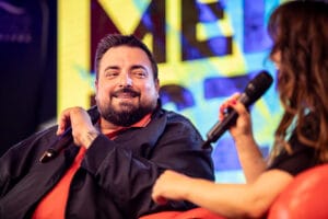 Osoba z mikrofonem na scenie podczas wywiadu.