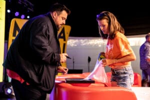 Osoby podpisują zdjęcie na wydarzeniu kulturalnym.