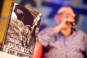 Książka „Moja podróż” na tle rozmazanej postaci