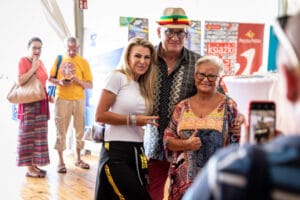 Ludzie pozują do zdjęcia, uśmiech i kciuki w górę.