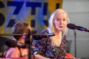 Kobieta i dziecko rozmawiają podczas nagrania podcastu.