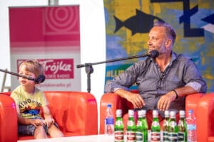 Rozmowa na scenie z mikrofonami, mężczyzna i dziecko.