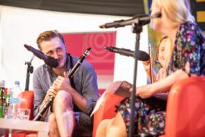 Muzyk z klarnetem na scenie podczas rozmowy.