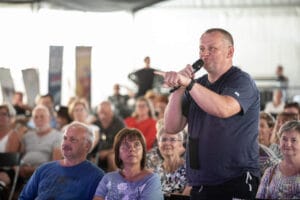 Mężczyzna z mikrofonem przemawia do publiczności.