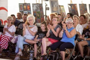 Ludzie na widowni, klaszczą podczas wydarzenia.