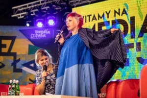 Dwie kobiety na scenie z mikrofonami na festiwalu.