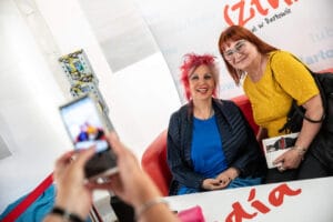 Kobiety na spotkaniu autorskim, zdjęcie robione telefonem.