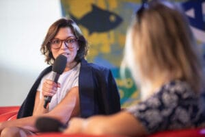 Kobieta z mikrofonem na wydarzeniu lub konferencji.