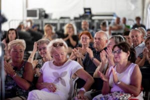 Publiczność oklaskuje podczas wydarzenia w namiocie.