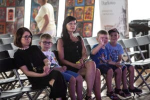 Ludzie siedzący na krzesłach podczas wydarzenia.