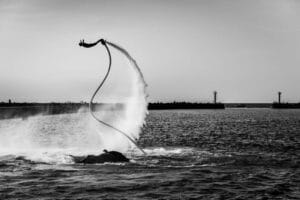 Człowiek na flyboardzie unosi się nad wodą.