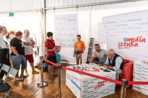 Ludzie czekają w kolejce na podpis artysty.