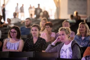 Ludzie siedzący na konferencji, skupieni na prezentacji.