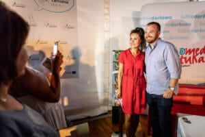 Para pozująca do zdjęcia na wydarzeniu promocyjnym.