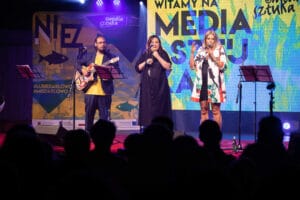 Trzy osoby na scenie podczas festiwalu w Darłowie.
