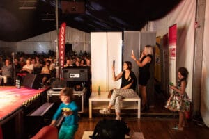 Ludzie nagrywają koncert na telefonach w namiocie.