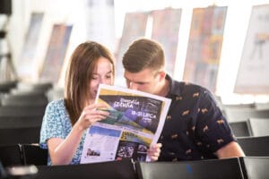 Para czyta gazetę na wydarzeniu kulturalnym.