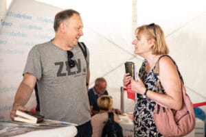 Ludzie rozmawiający na targach książki w Darłowie.