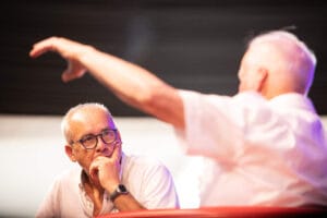 Dwaj mężczyźni w dyskusji na scenie konferencyjnej.